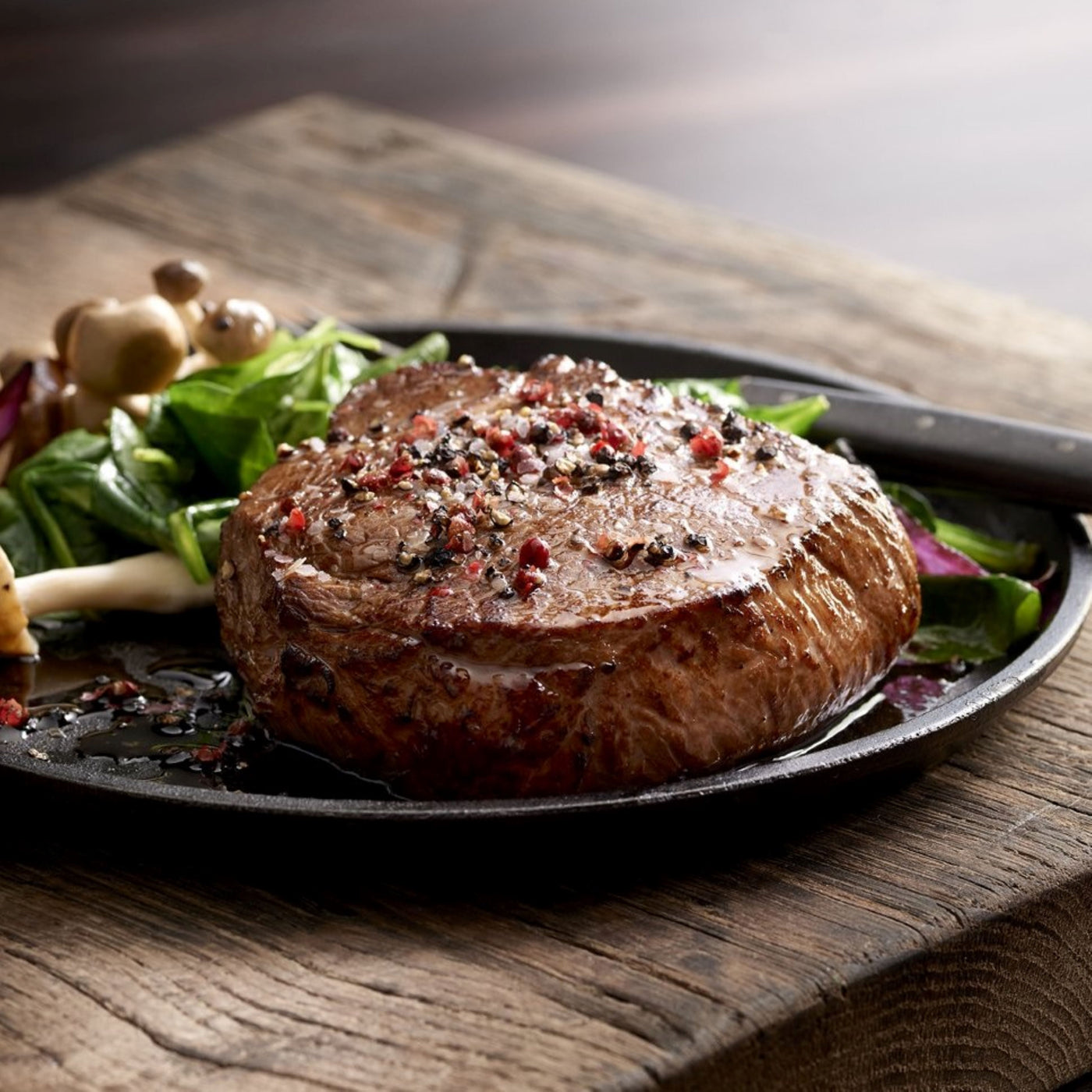 cooked usda choice top sirloin steak on plate with salad and seasoning